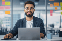 A man in an office working on a laptop