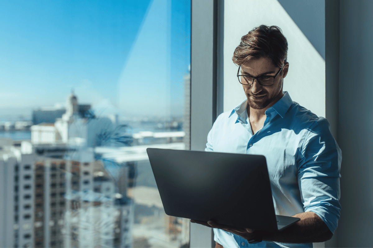 A man standing with a laptop