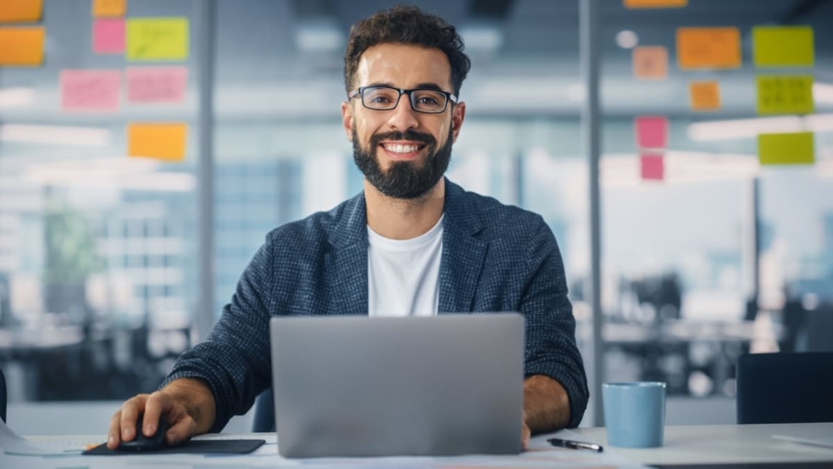 A man with a laptop in a modern office