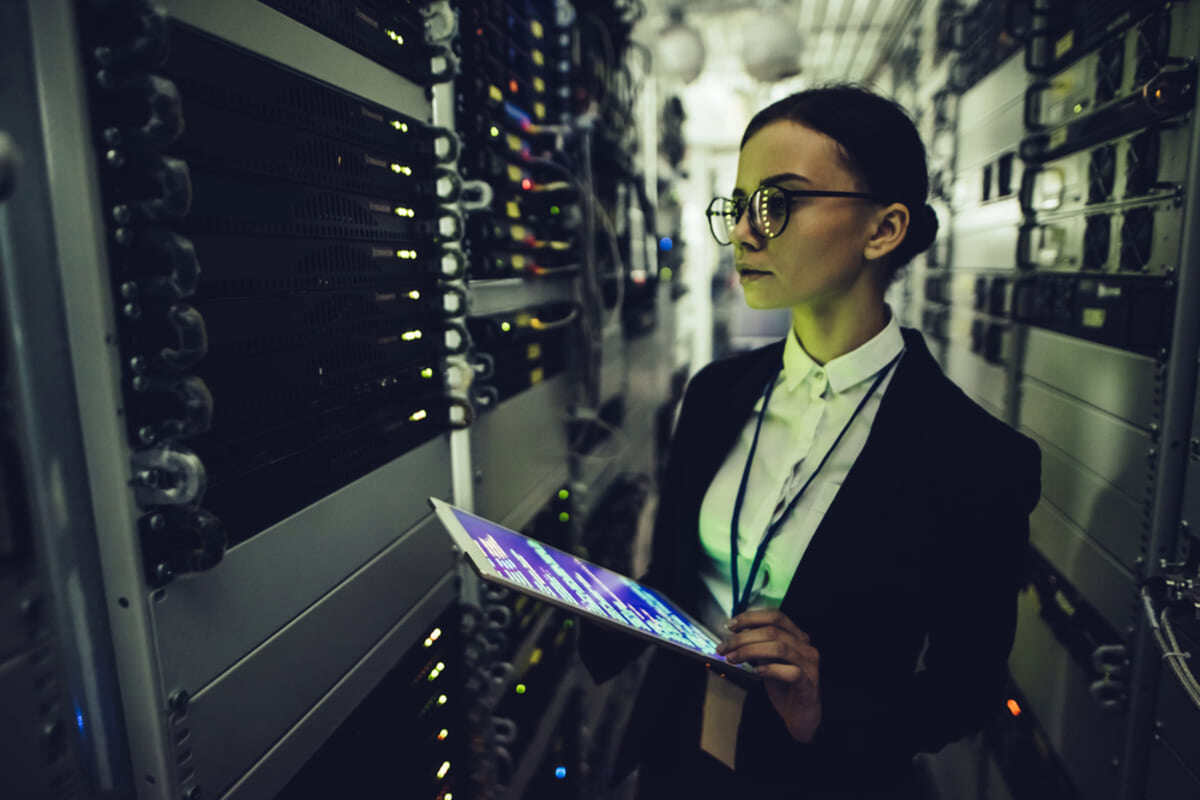 A person examining a server working on a tablet, benefits of managed IT services concept