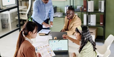  Small group of people working around a laptop 