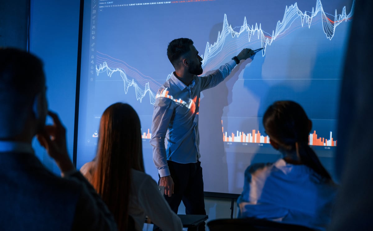 Team members having a meeting looking at a graph