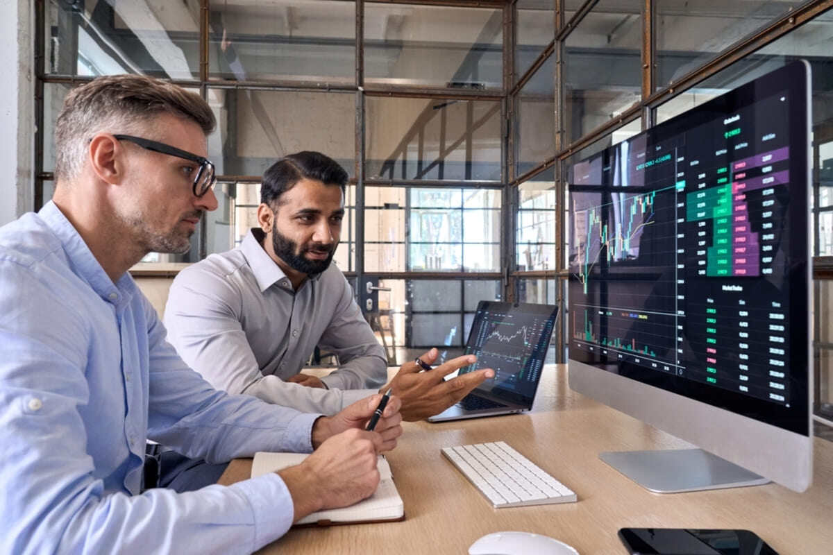 Two people discussing a graph on a computer