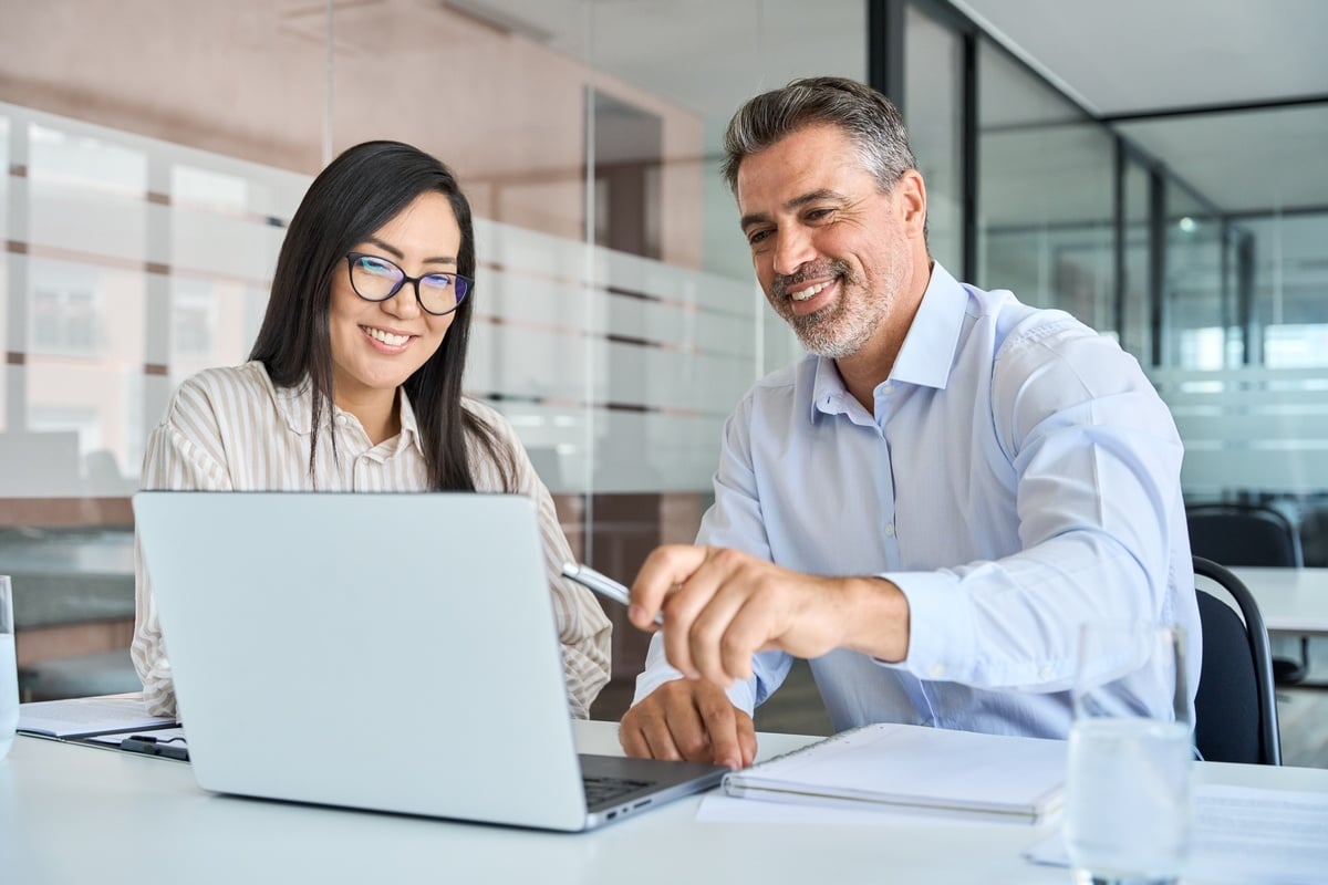 Two people working together on a laptop