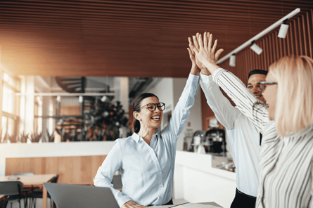 Three professionals high-fiving Three professionals high-fiving