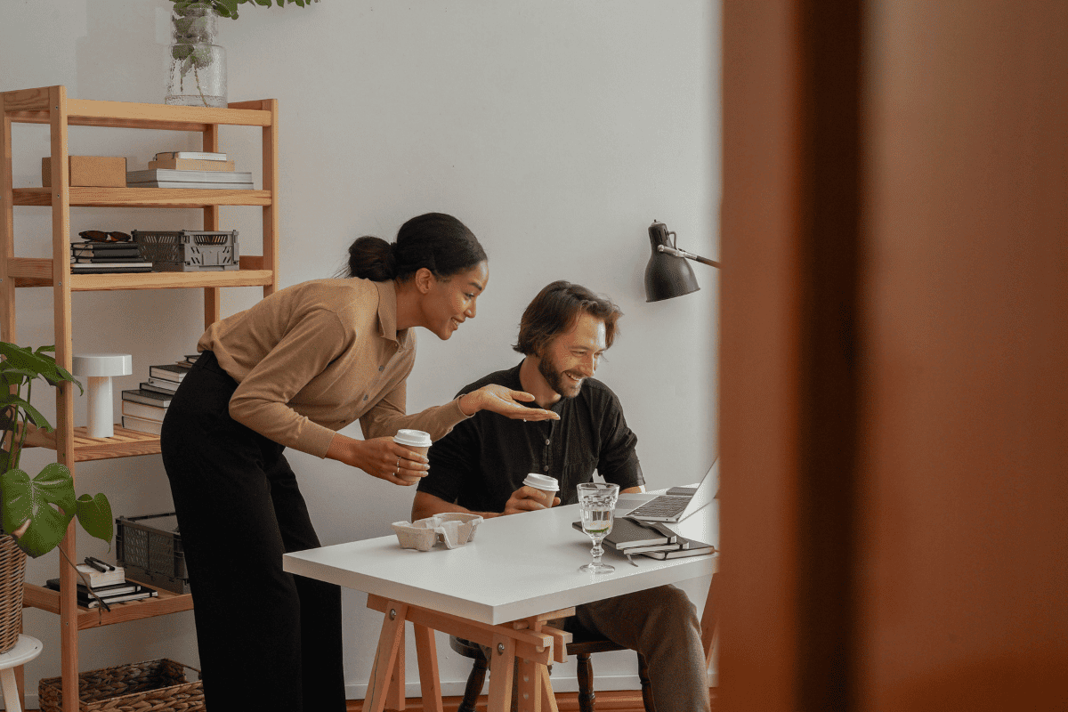 Two professionals working at a computer in a modern office