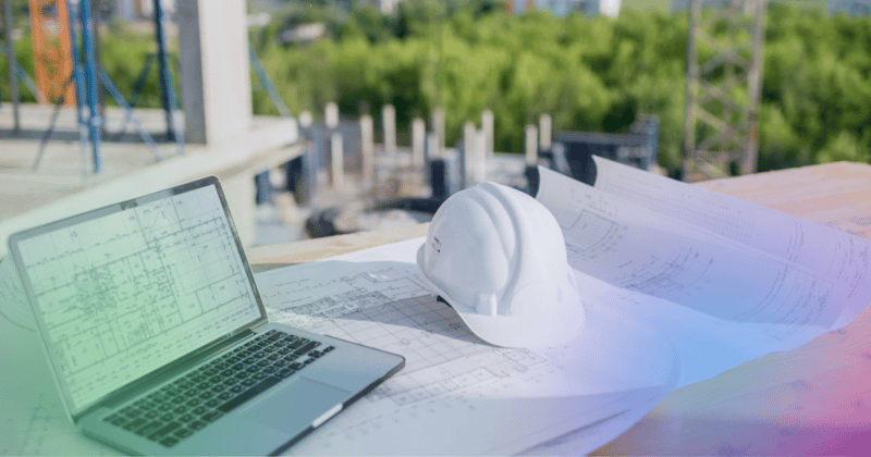 Construction engineer working on floor plans and laptop