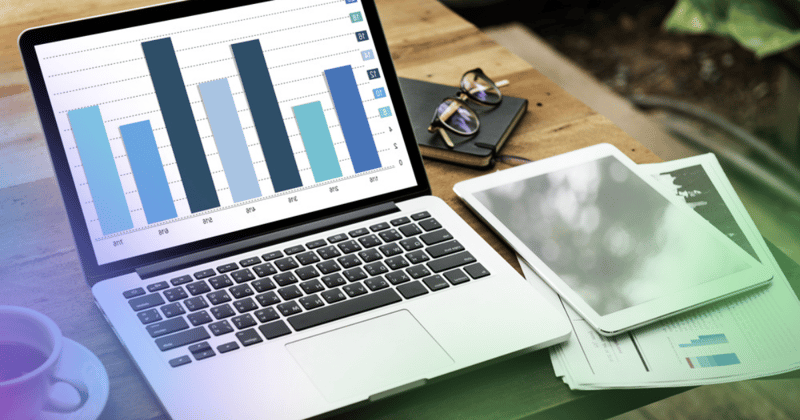 Tablet with graphs on desk with other graphs on paper