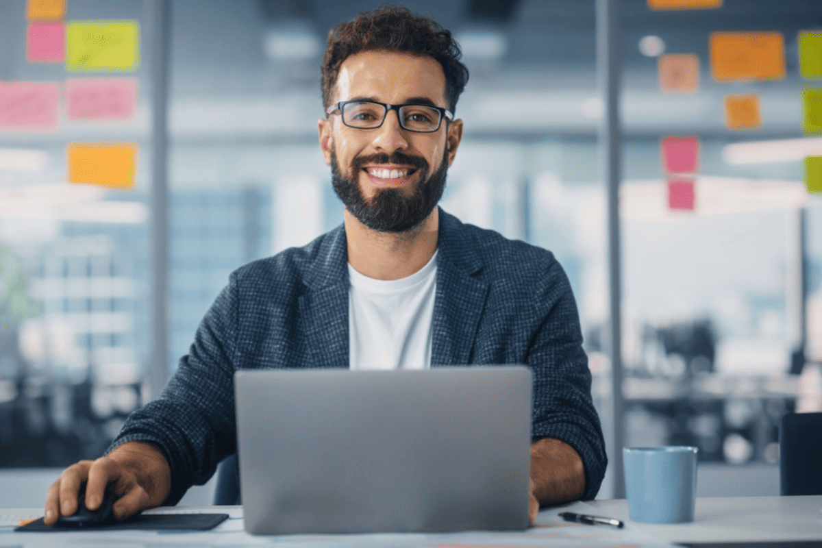 A man in an office working on a laptop.