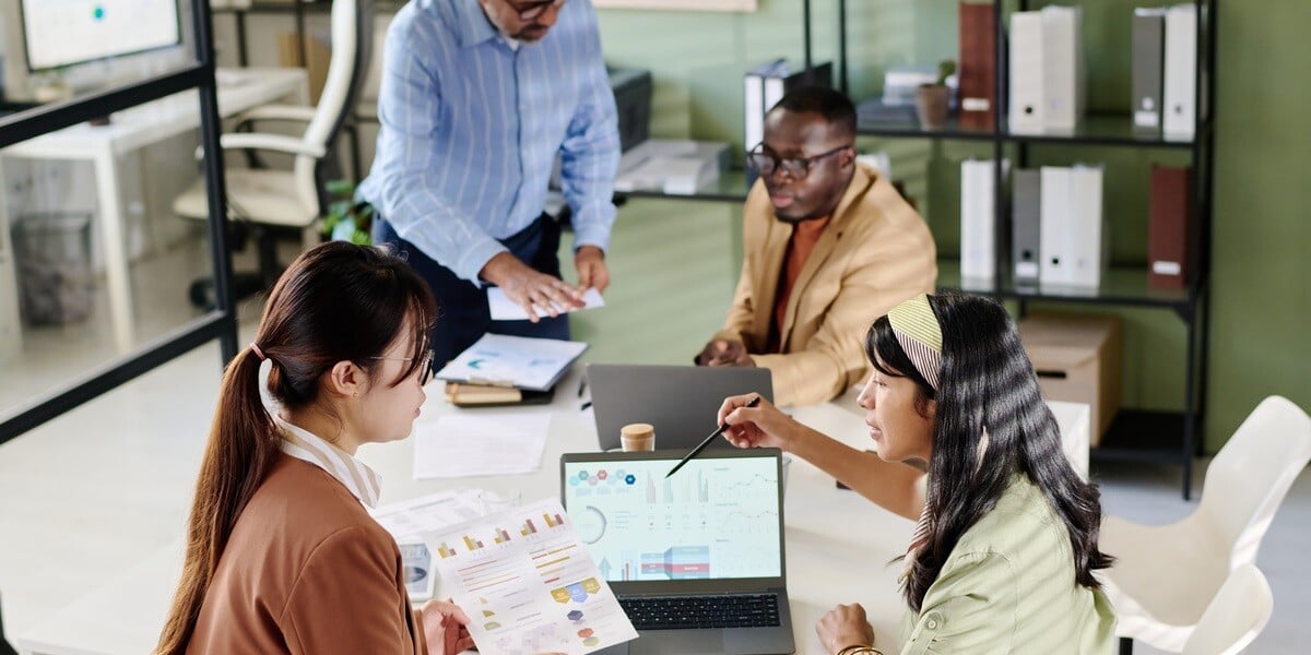 Small group of people working around a laptop