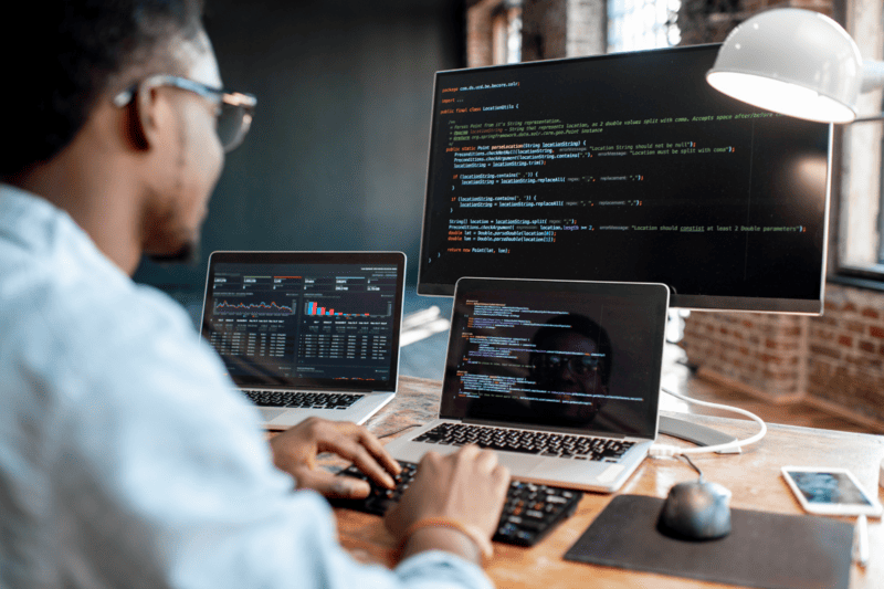 A professional looking at code on a computer.