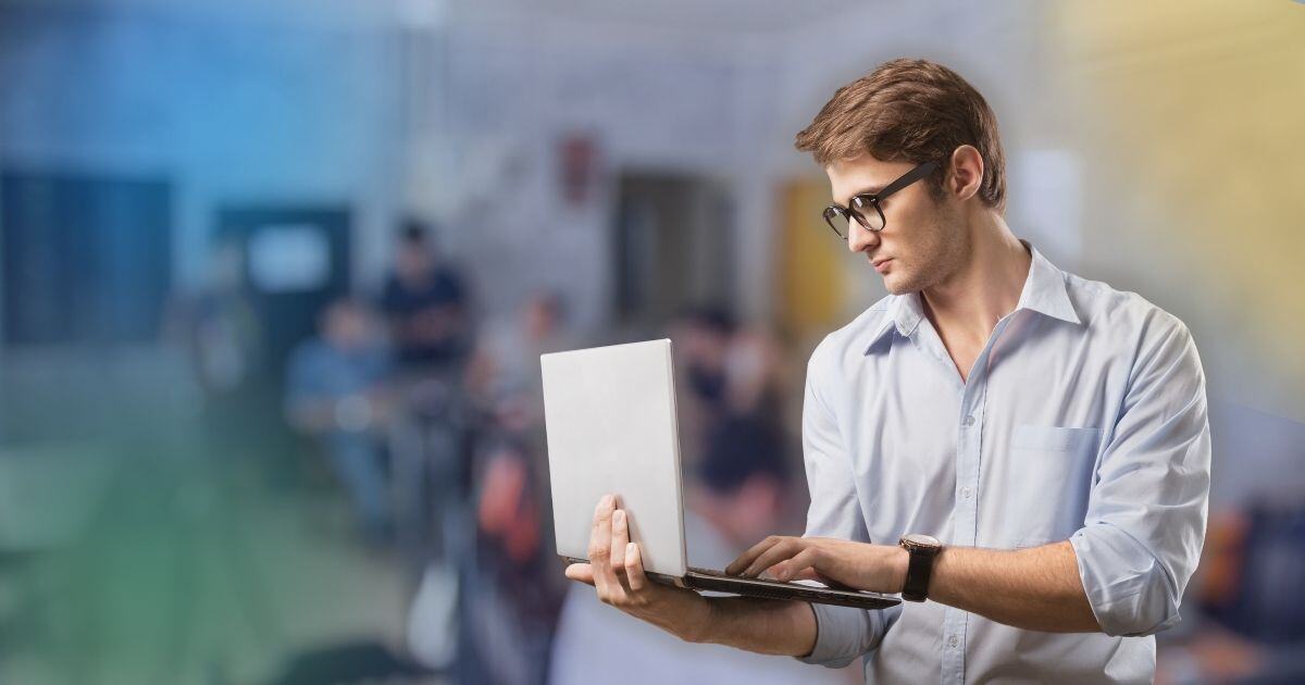 Businessman reading from laptop on his hand