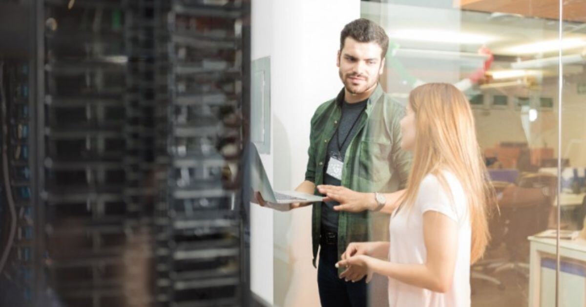 IT workers talking by a server